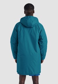 Teal lång pufferjacka med huva, med en slät yta, rymlig passform och elastiska ärmmuddar, som går ner till mitten av låret.