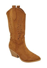 Botte de cowboy en suède beige avec un bout pointu, des motifs découpés sur la tige et un talon empilé. Présente des détails de couture et des tirettes sur le col.