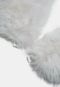 Tessuto in finta pelliccia bianca con un aspetto morbido e texturizzato. Presenta due linguette color argento sui bordi per il fissaggio.