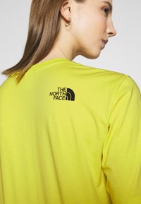 T-shirt giallo a maniche corte con logo nero sul retro. Realizzato in tessuto morbido con una vestibilità comoda e scollo rotondo.