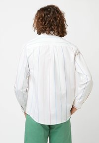 Witte button-up shirt met verticale meerkleurige strepen in rood, blauw, groen en geel. Lange mouwen en een gebogen zoomontwerp.