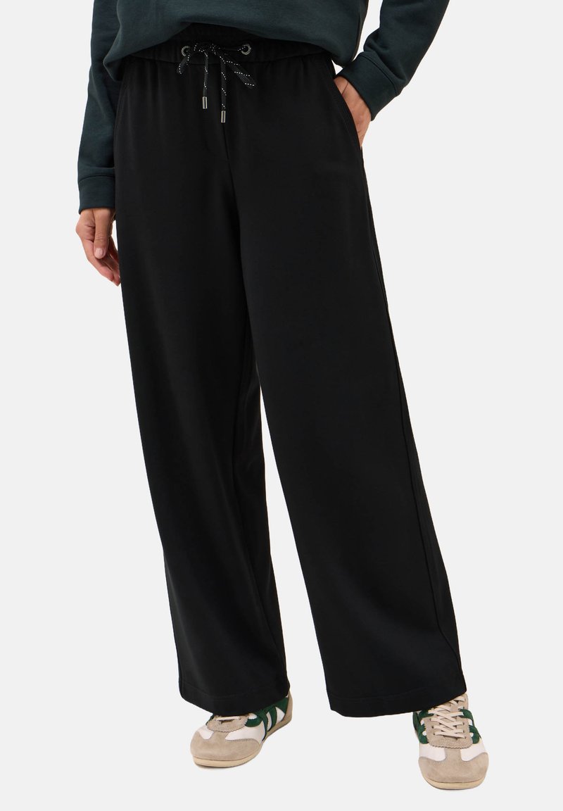 Schwarze, weite Sweathosen mit Zugbandbund und silbernen Hardware-Akzenten, aus weichem Material und mit Seitentaschen.