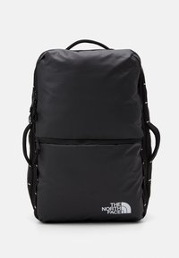 Svart ryggsäck med rektangulär form, tillverkad av slitstarkt tyg. Har två fickor med dragkedja och en vit logotyp på framsidan.