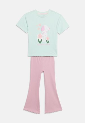 Ανοιχτό μπλε κοντομάνικο πουκάμισο με σκύλο με ροζ βούλες, λουλούδια, πεταλούδες και το κείμενο «Always by my side», σε συνδυασμό με ροζ παντελόνι με καμπάνα.