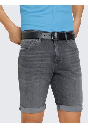 Homme portant un short en denim gris foncé retroussé avec une ceinture noire et une chemise bleu clair rentrée.