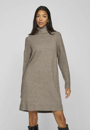 Turtleneck klänning av lätt brun stickad tyg, med lång ärm och ribbat nederkant, som faller ovanför knäet.
