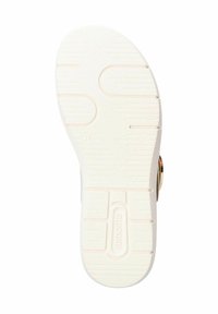 Semelle d'une sandale avec une surface en caoutchouc texturé comportant des rainures, de couleur principalement blanche, et un accent doré près du talon.