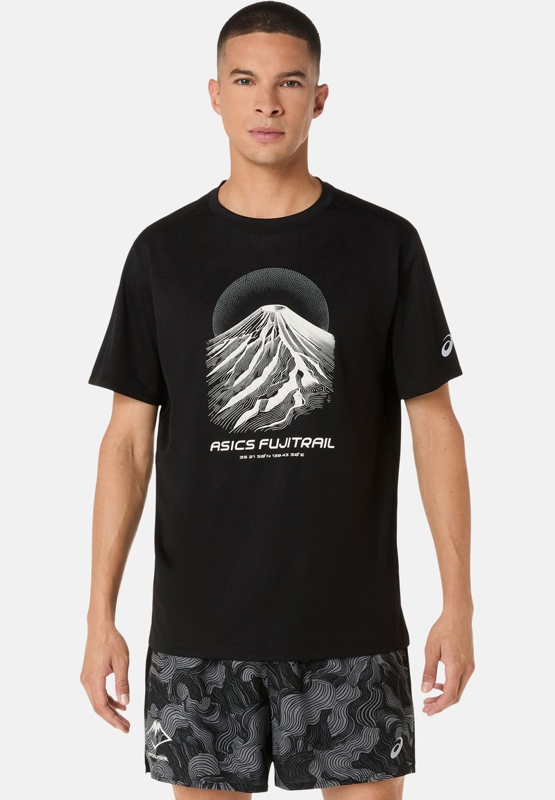 Sort T-shirt med en grafik af Mount Fuji i hvid, med bølgede linjer og cirkulære detaljer; kombineret med mønstrede sorte shorts.