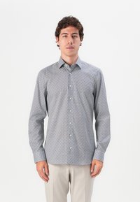 Wrinkle-resistant button-down shirt in lightweight fabric, featuring a geometric pattern in blue, white, and maroon tones, long sleeves.