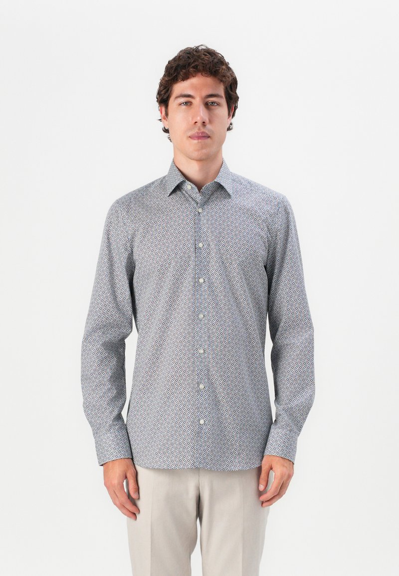 Wrinkle-resistant button-down shirt in lightweight fabric, featuring a geometric pattern in blue, white, and maroon tones, long sleeves.