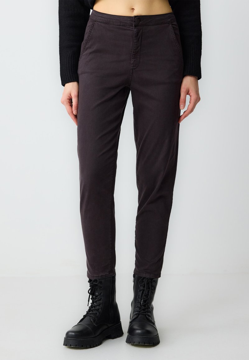 Donkergrijze, slim fit broek van katoenmix, voorzien van een knoopsluiting en zijzakken, gecombineerd met zwarte veterschoenen.