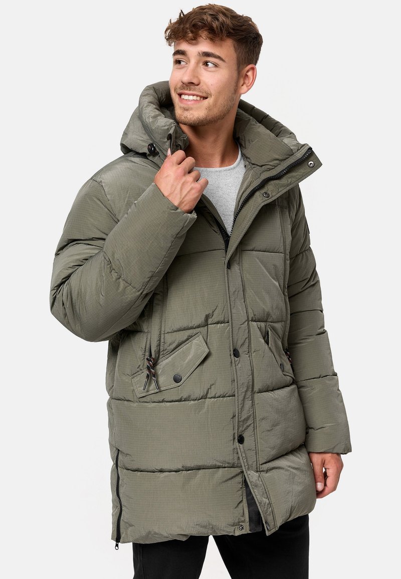 Padded olive green parka jacket with a hood, front zip, snap buttons, two front pockets, and drawstring accents. Textured fabric finish.