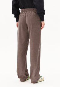 Pantalon en velours côtelé gris avec une coupe décontractée, doté d'une taille élastique et d'une poche arrière unique, présenté de dos.