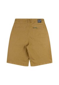 Brune shorts laget av stoff, med to baklommer, en synlig midje og et logo-patch på venstre bakside.