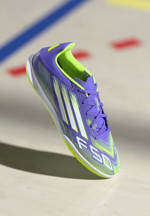 Purple and neon green athletic shoe with a sleek design, featuring horizontal stripes, a textured upper, and a lightweight sole.