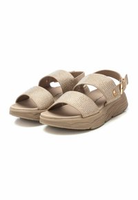 Sandalias beige con dos correas anchas adornadas con pequeñas piedras brillantes, suela texturizada y una correa adjustable en el tobillo con un hebilla dorada.