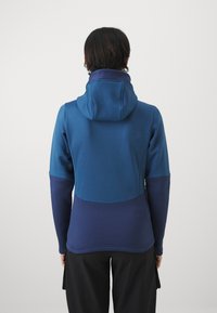 Felpa con cappuccio blu dal design color-block; presenta una texture morbida e una silhouette aderente, con un logo sul retro.