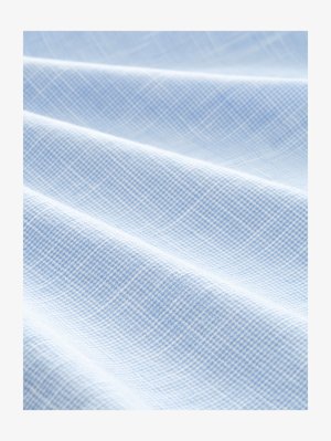 Lichtblauwe stof met een geweven rasterpatroon. De textuur is glad met zichtbare plooien, wat wijst op een zacht en lichtgewicht materiaal.