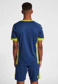 Marineblauwe sporttrui en shorts met limoen groene accenten, voorzien van een gestructureerde stof en een ronde hals ontwerp.
