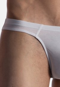 Weiße Baumwoll-Unterhose mit glatter Textur und elastischem Bund, körpernah geschnitten, mit minimalen Nähten und einem schlichten Design.