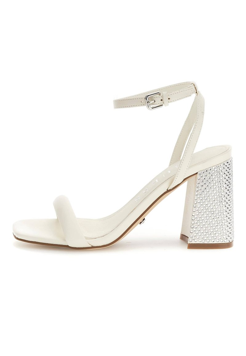 Sandal con tacco alto bianco, con una fascia larga sul dito, cinturino alla caviglia con fibbia e un tacco a blocco testurizzato decorato con strass.