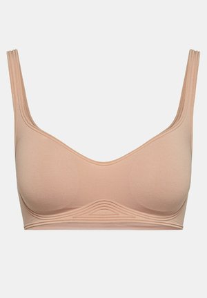 Reggiseno color pesco realizzato in tessuto morbido, con un design liscio e senza cuciture, arricchito da dettagli a coste lungo il sottogola e spalline larghe.