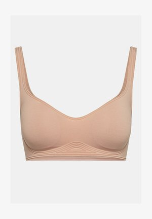 Reggiseno color pesco realizzato in tessuto morbido, con un design liscio e senza cuciture, arricchito da dettagli a coste lungo il sottogola e spalline larghe.