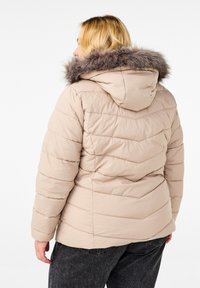 Béžová puffa bunda s odnímatelnou kapucí z umělé kožešiny, s horizontálně prošívanými detaily a elastickými manžetami pro teplo. Zobrazeno ze zadní strany.