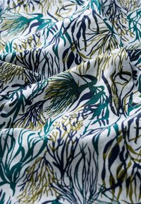Baumwollstoff mit einem botanischen Druck in Dunkelgrün, Marineblau und Senfgelb auf einem weißen Hintergrund, mit einer strukturierten und glatten Optik.
