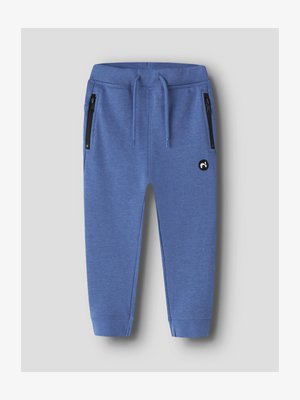 Pantaloni da jogging per bambini blu con vita elastica, coulisse, tasche laterali con zip, polsini a coste e un piccolo logo circolare nero sulla coscia.