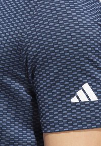 Navy blue athletic shirt with a textured grid pattern, short sleeves, and a white Adidas logo on the lower sleeve.