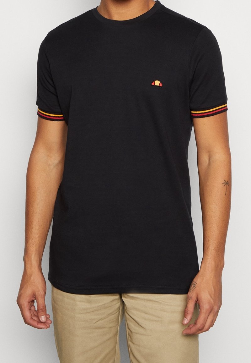 Černé bavlněné tričko s krátkými rukávy, které má červené, žluté a černé pruhy na manžetách a malé logo na hrudi.