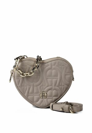 Bolso acolchado de color topo con forma de corazón, asa de cadena dorada y correa de hombro desmontable a juego sobre fondo blanco.