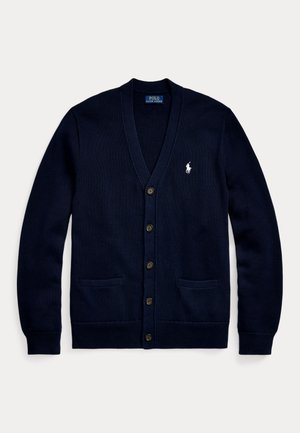 Námorně modrý pletený cardigan s výstřihem do V, předním zapínáním na knoflíky, dvěma předními kapsami a malým bílým logem na hrudi. Měkká textura a uvolněný střih.