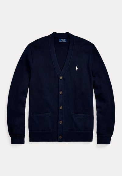 Marinblå stickad cardigan med V-hals, knäppning fram, två framfickor och en liten vit logotyp på bröstet. Mjuk textur och avslappnad passform.