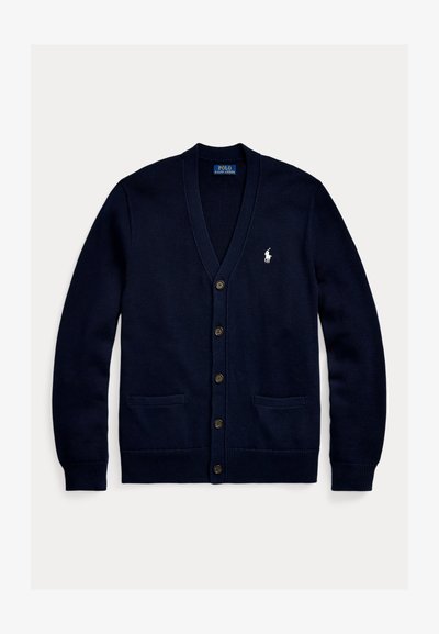 Marinblå stickad cardigan med V-hals, knäppning fram, två framfickor och en liten vit logotyp på bröstet. Mjuk textur och avslappnad passform.