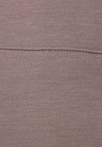 Mauve audums ar gludu tekstūru, ar smalku adījumu rakstu un redzamām šuvēm. Materiāls ir elastīgs un viegls.