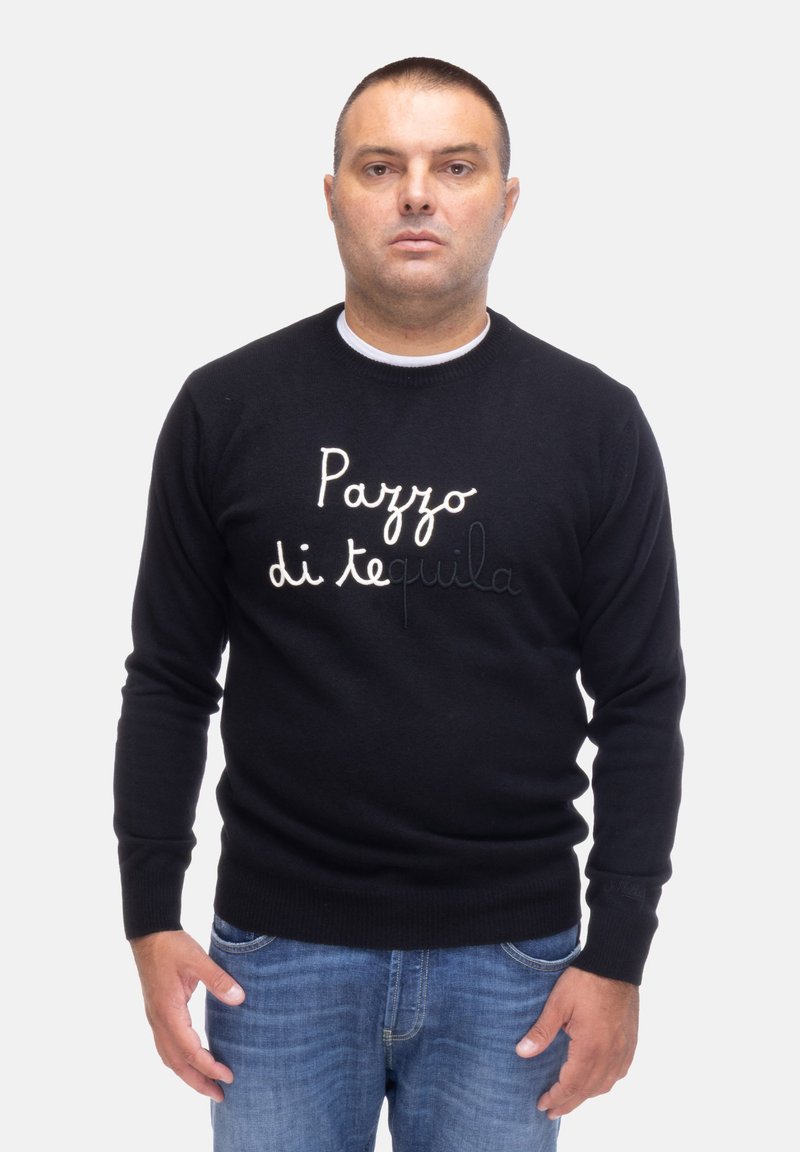 Maglione nero con collo tondo, con testo ricamato bianco "Pazzo di tequila" sulla parte frontale, abbinato a jeans blu.