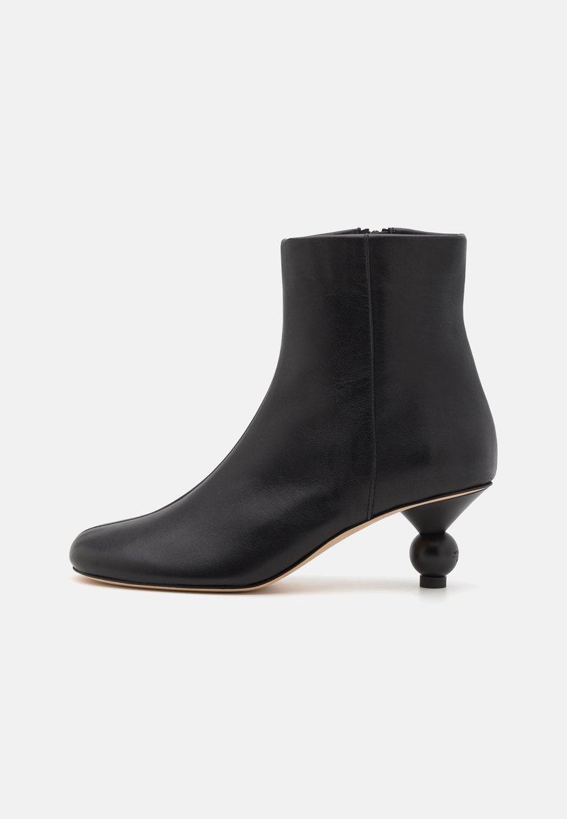 Botină neagră din piele, cu un design ajustat, vârf rotund și un toc sferic distinctiv. Textură netedă cu o siluetă minimalistă.
