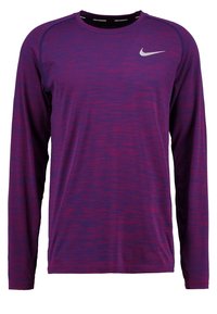 Fioletowa i czerwona, melanżowa koszulka do biegania Nike z długim rękawem, okrągłym dekoltem i białym logo Nike na lewym przodzie klatki piersiowej.