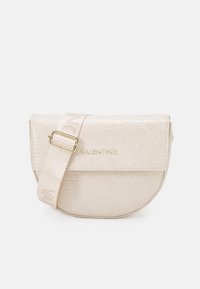 Beige kabelka crossbody ve tvaru půlměsíce s embossovaným krokodýlím vzorem, nastavitelným popruhem a zlatým logem "VALENTINO" na přední klopě.