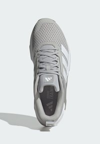 Šedá atletická bota s prodyšnou textilií, strukturovanými akcenty, plochými tkaničkami a třemi bílými pruhy na boku; polstrovaná patka pro pohodlí.