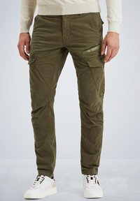 Olivenfarbene Cargo-Hosen mit mehreren Taschen, schmaler Schnitt, texturierten Stoff; kombiniert mit weißen Sneakers mit schwarzen und beigefarbenen Akzenten.