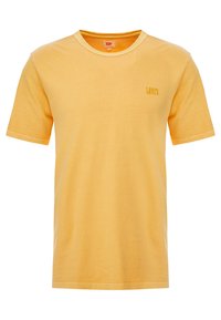 Žluté bavlněné tričko s krátkým rukávem a kulatým výstřihem. Na přední straně se nachází jemné vyšívané logo Levi's v odpovídající barvě nitě.