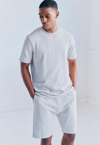 Light grey short-sleeve t-shirt and shorts set with a textured geometric pattern, made from soft fabric, with a relaxed fit and ribbed neckline.