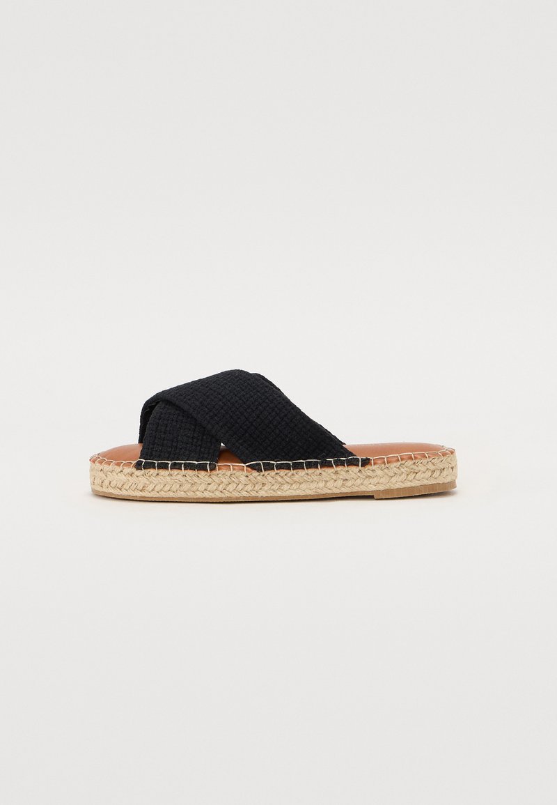 Svart vevd espadrille sklidesandal med kryssende stropper, brunt fotbed og jute såle. Flat design uten synlig maskinvare eller detaljer.