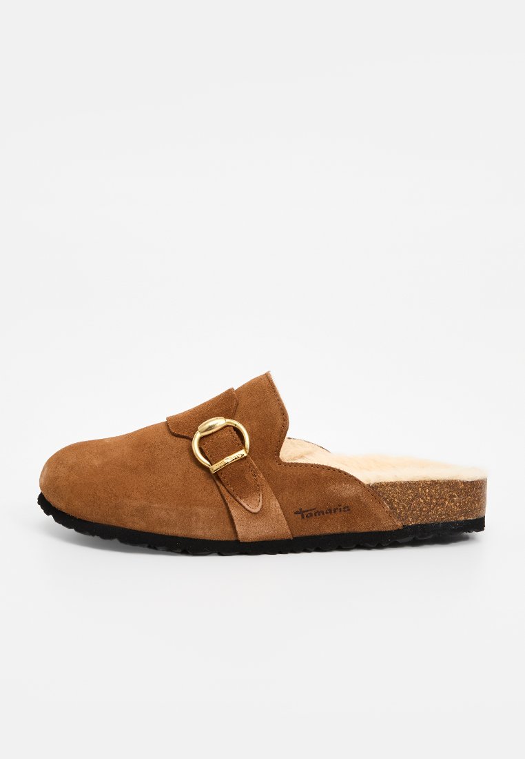 Bruine suede instapklompen met een goudkleurige gesp accent, voorzien van een gezellige nepbontvoering en een gestructureerde zwarte rubberen zool.