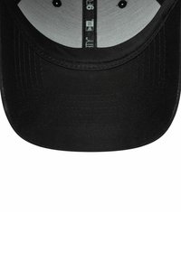 Casquette noire avec une visière courbée, ornée d'un tissu texturé et d'une doublure intérieure lisse. Comprend des détails de couture le long du bord.