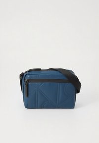 Bolso bandolera rectangular azul con correa negra ajustable, bolsillo con cremallera frontal y sutil patrón geométrico cosido en tela lisa.