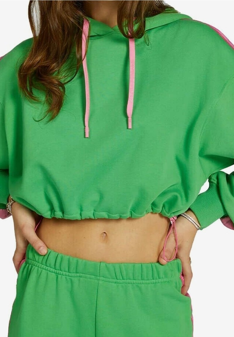 Groene cropped sweatshirt met roze trekkoorden; voorzien van een gerimpelde zoom en lange mouwen. Gecombineerd met bijpassende groene shorts.